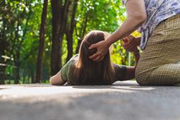 a woman with a head injury lying on the ground