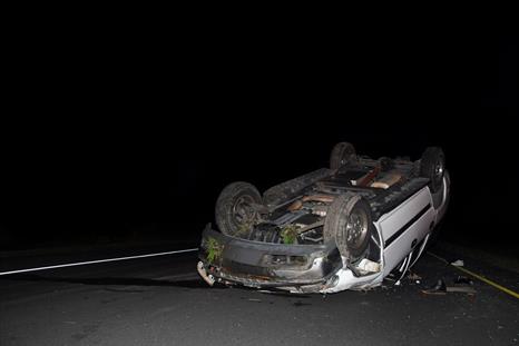 an overturned car on a road at night