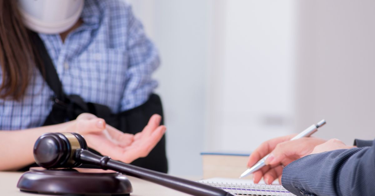 Injured woman talking to a personal injury attorney taking notes