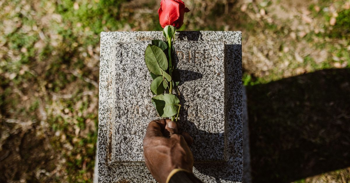 laying flower on gravestone