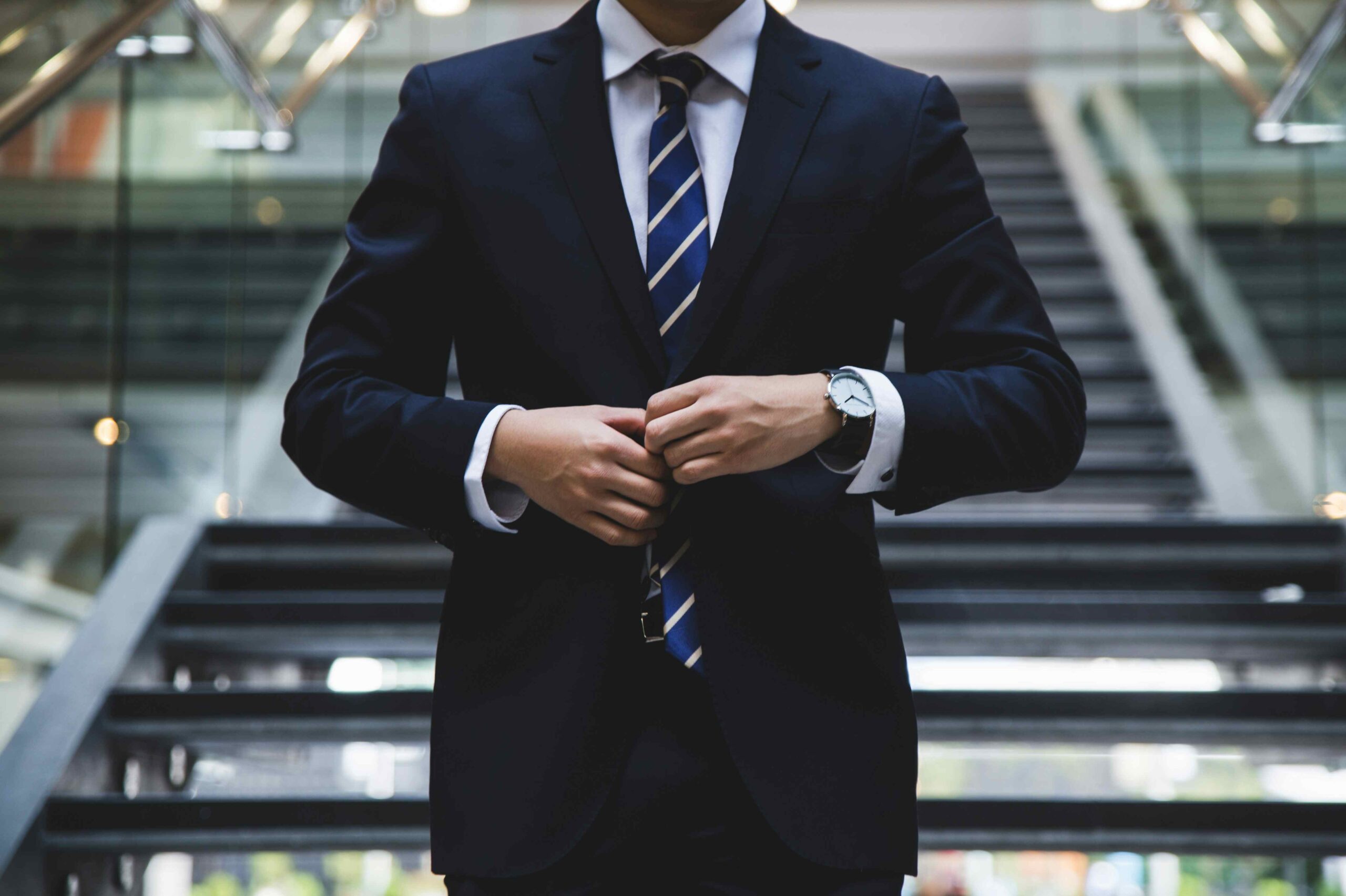 Image of lawyer adjusting the buttons on their suit.