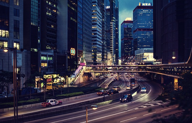 Image of a city at night with cars driving through major highways at the center.