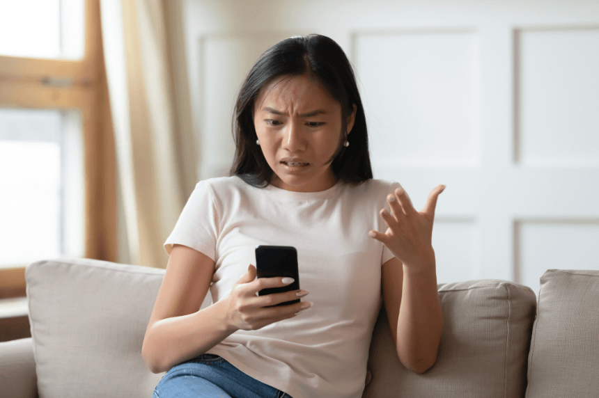 Woman upset while on social media on cell phone