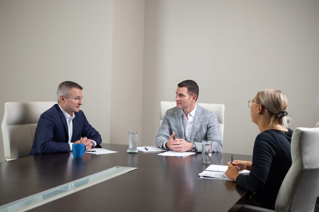 Attorneys at DM Injury Law meeting with a client in a conference room to discuss a legal case.