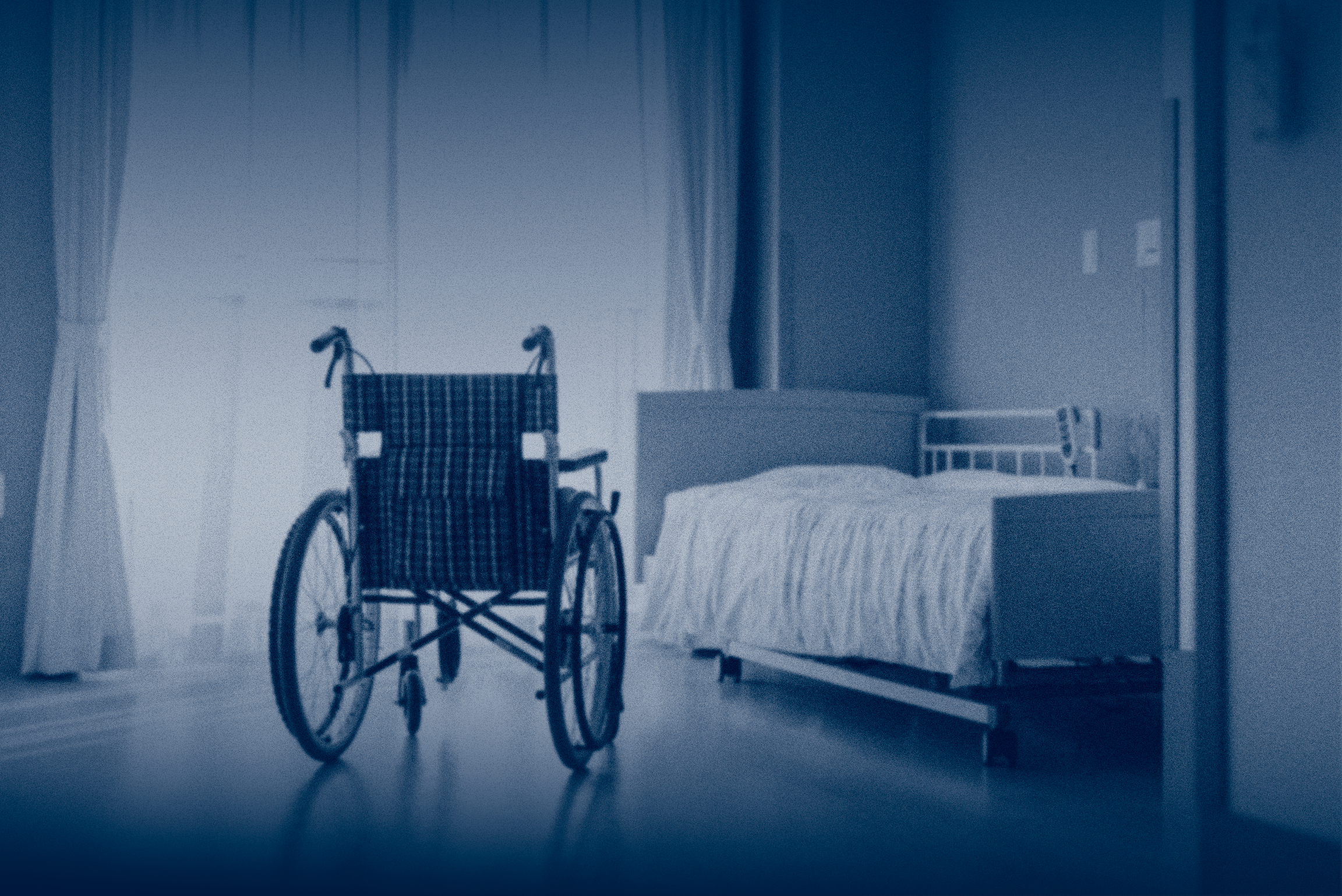 empty wheelchair and bed in nursing home