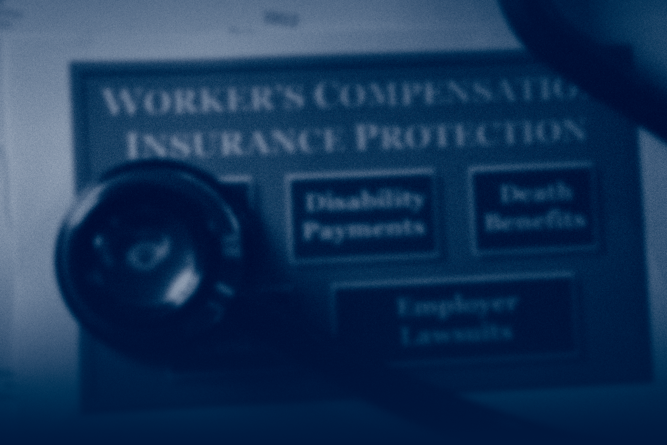 A blurred close-up of a workers’ compensation insurance document with a stethoscope resting on top, highlighting medical and benefit protections.