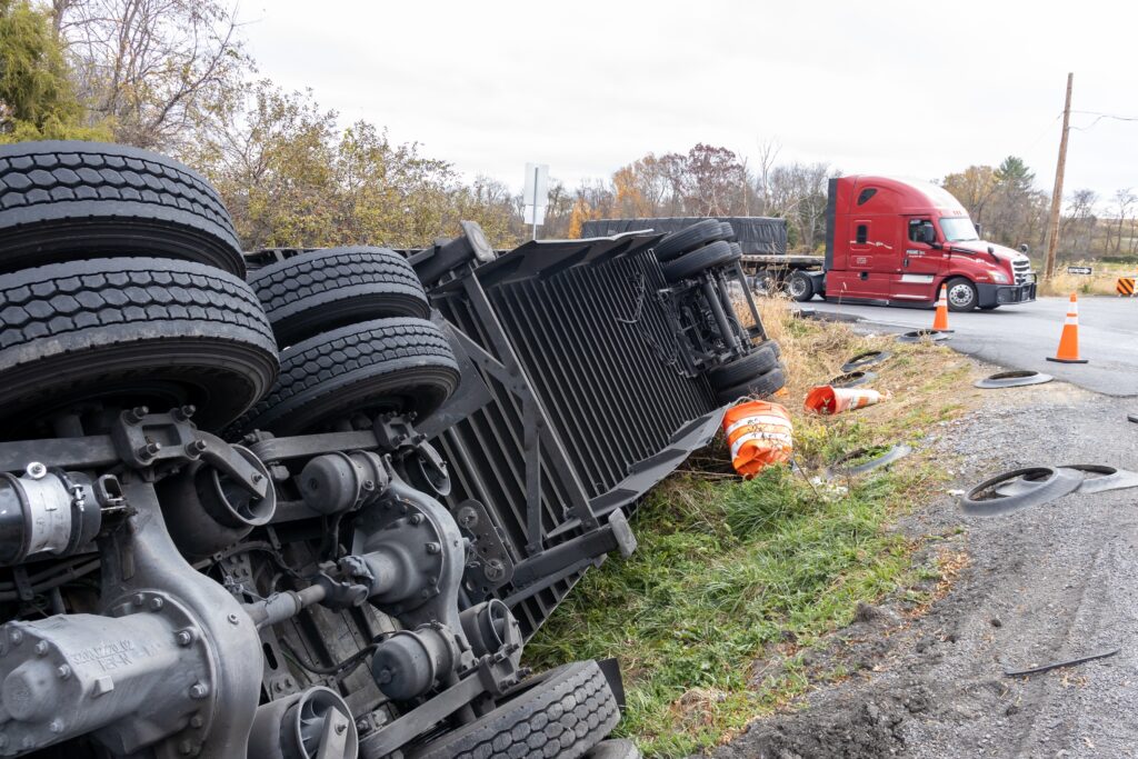 Overturned semi-truck on the side of the road with debris scattered, showing a serious crash often requiring help from an Oklahoma city truck accident lawyer.