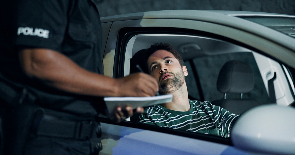 Man, officer and writing of ticket fine, registration and speeding for traffic warning. Person, law enforcement and licence for drunk driving, penalty receipt and transport risk of violation at night