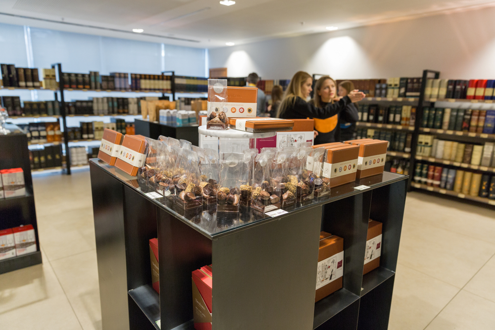 Chocolate sweets with old, rare and luxurious Single Malt Scotch Whisky bottles on store shelves at 3rd Ukrainian Whisky Dram Festival in Parkovy Exhibition Center