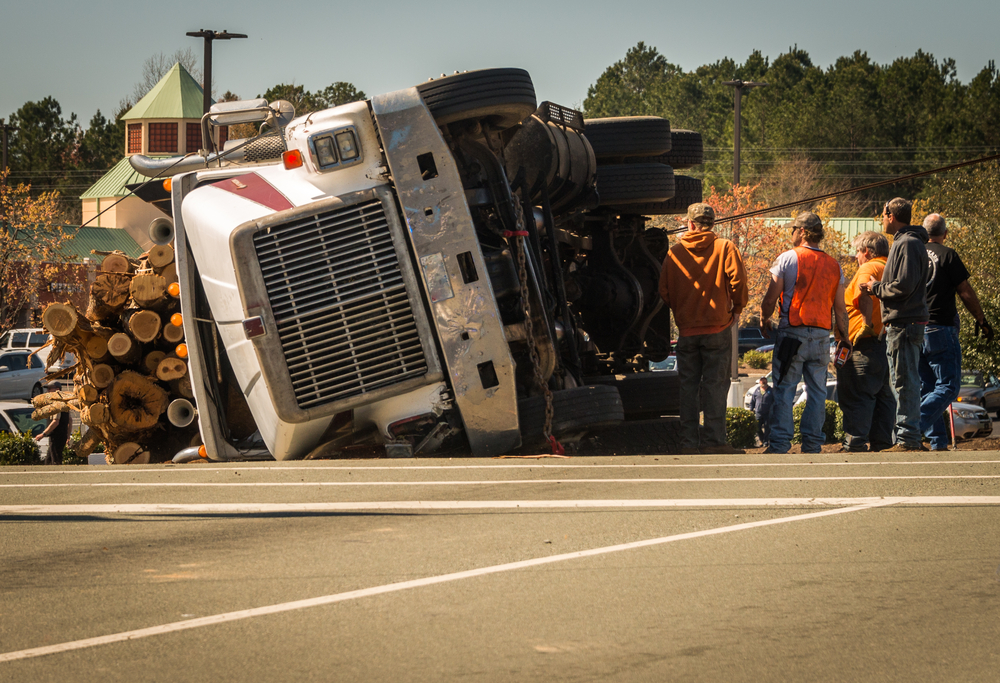 Overturned logging truck with workers