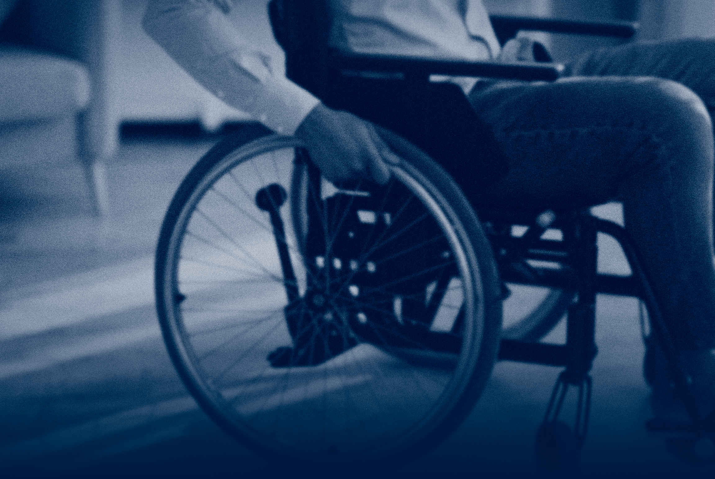 A person seated in a wheelchair, shown from the side, highlighting mobility challenges after a serious injury.